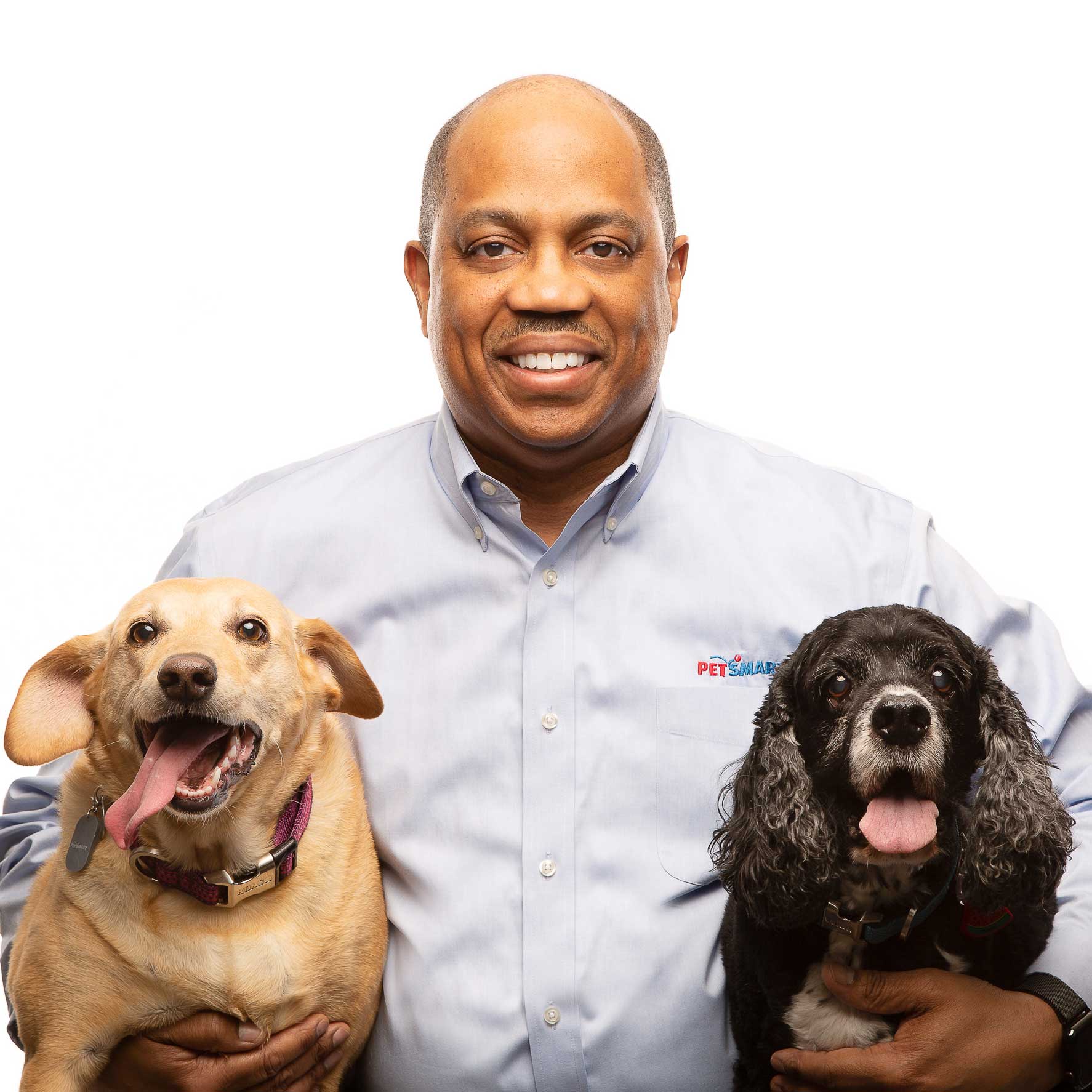 Mike Goodwin, CIO của PetSmart, ôm hai chú chó trong ảnh chân dung gắn vai trò lãnh đạo với tình yêu thú cưng.